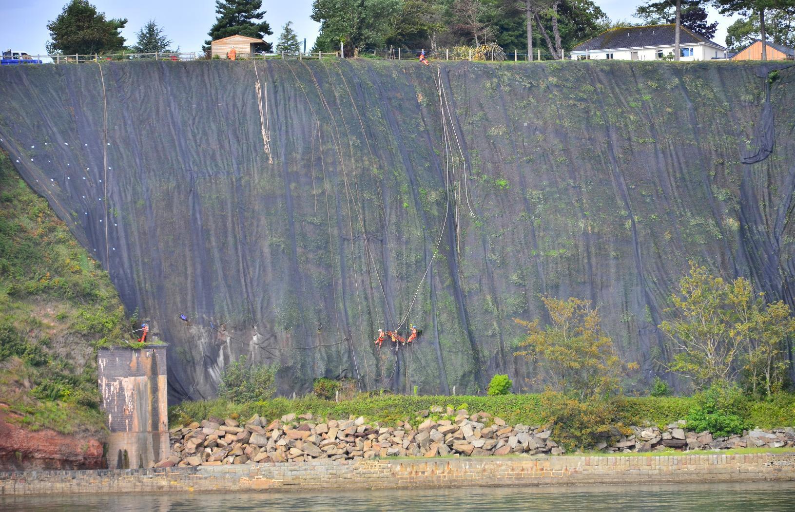 Workers working on cliff face to stabilize the slope